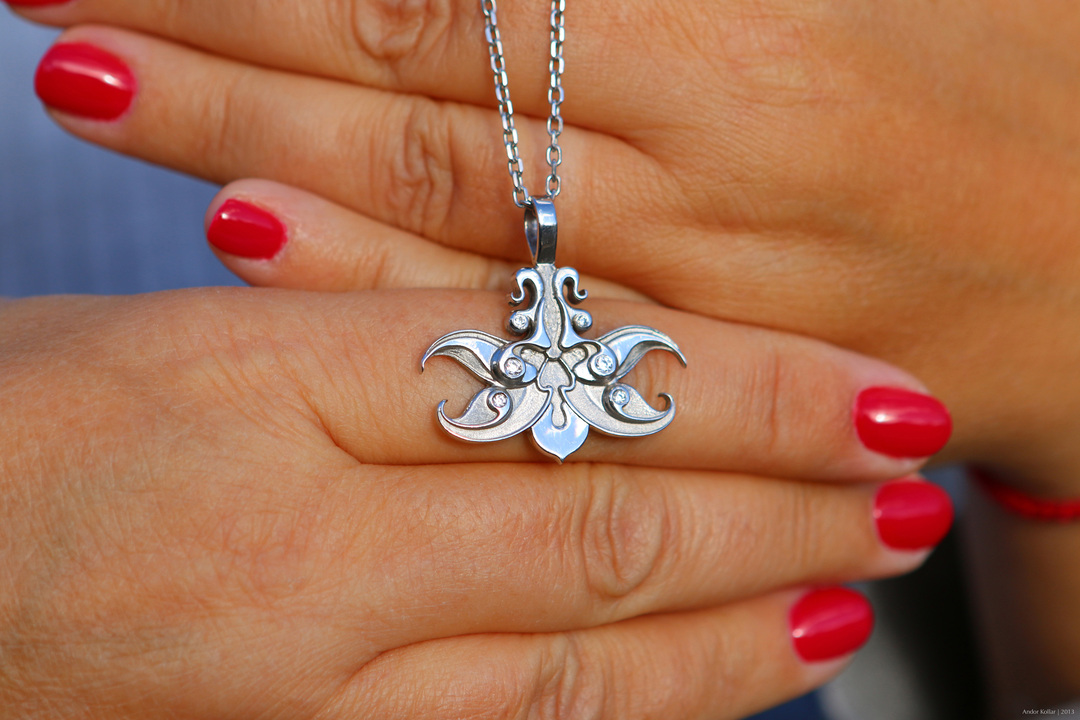 Orchid necklace jewelry design, white gold with diamonds, lady hand, red nails
